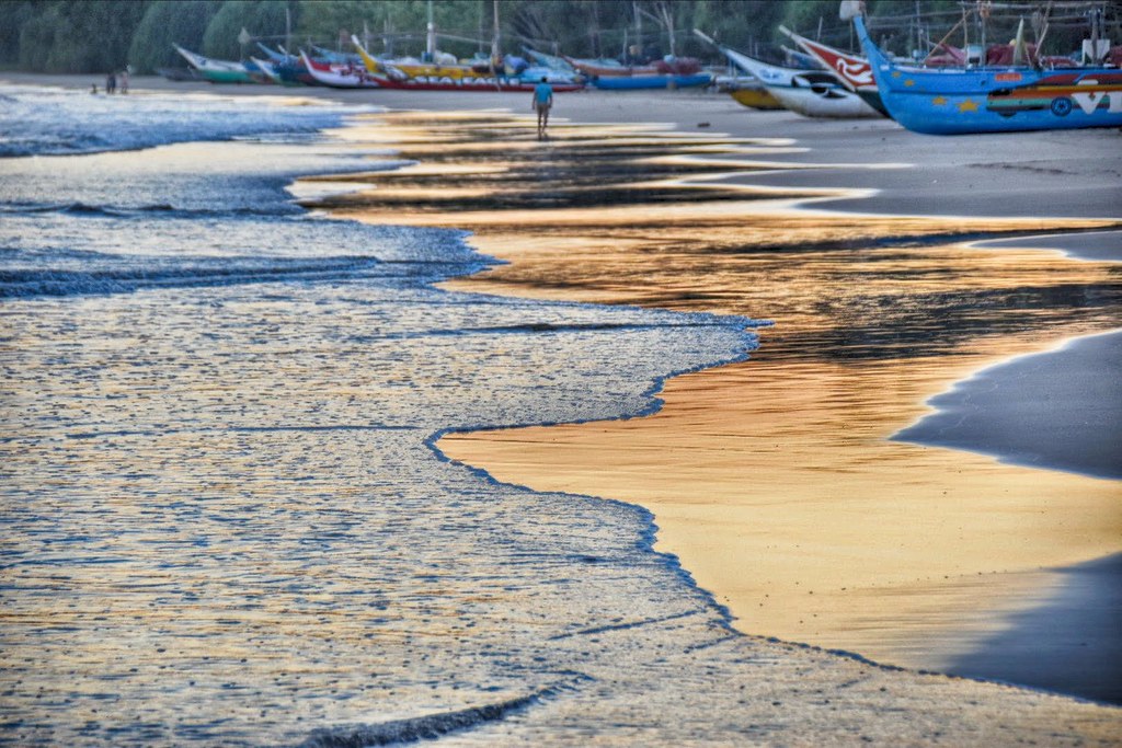 Sunset surf and beached boats on a quiet south-coast beach