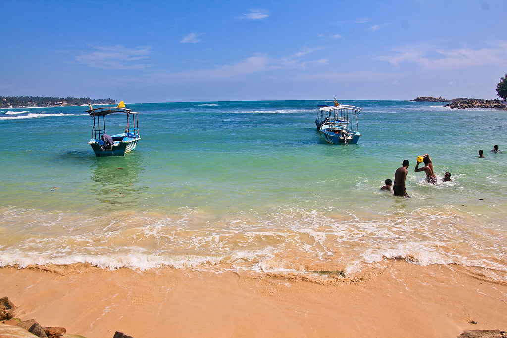 Swimmers and trip boats in Mirissa Bay