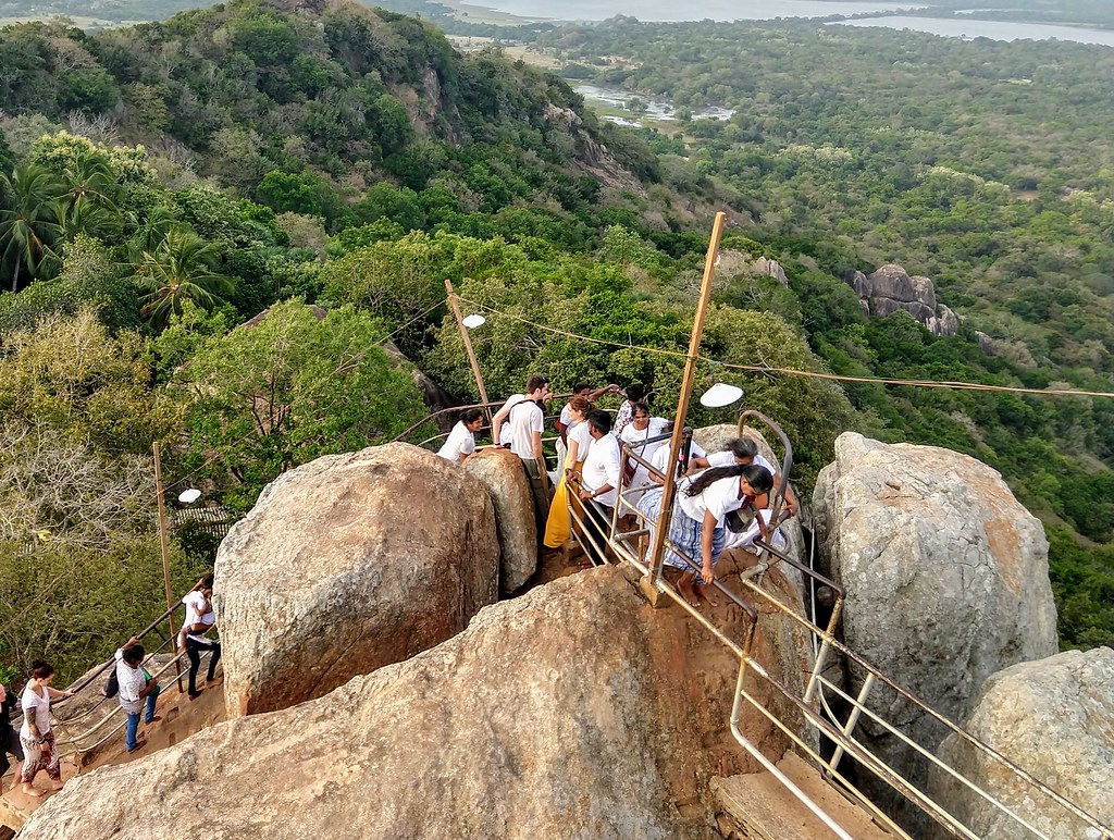 Pilgrims climbing the railed stairway up Mihintale rock