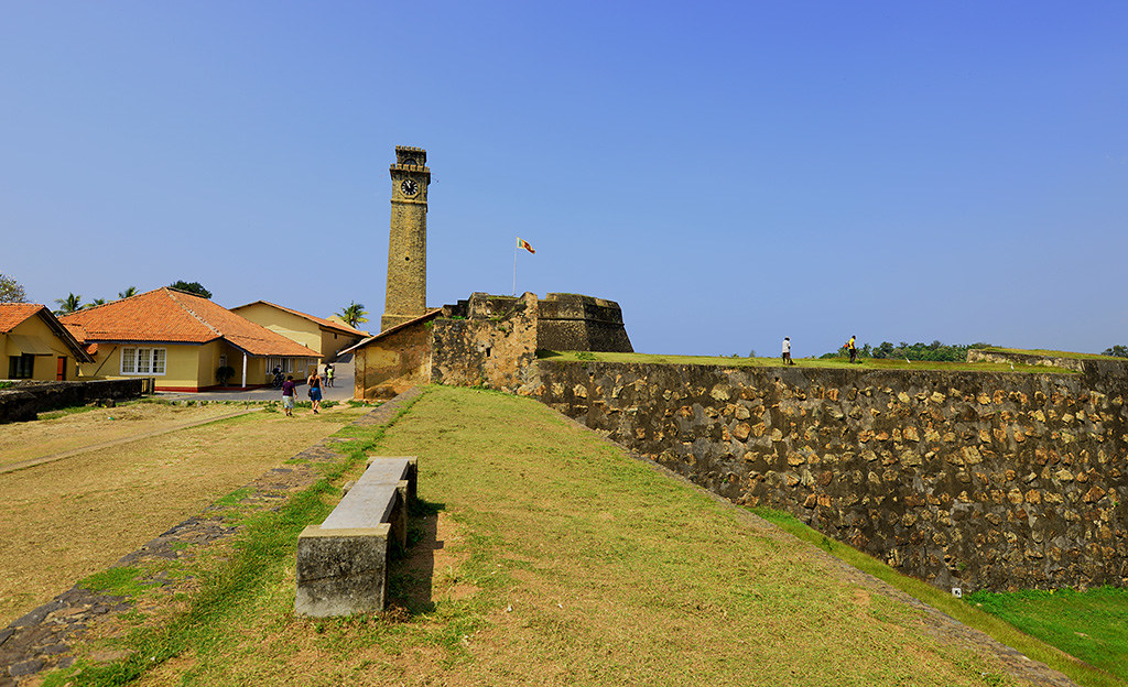 The clock tower and ramparts of Galle Fort with visitors walking the walls