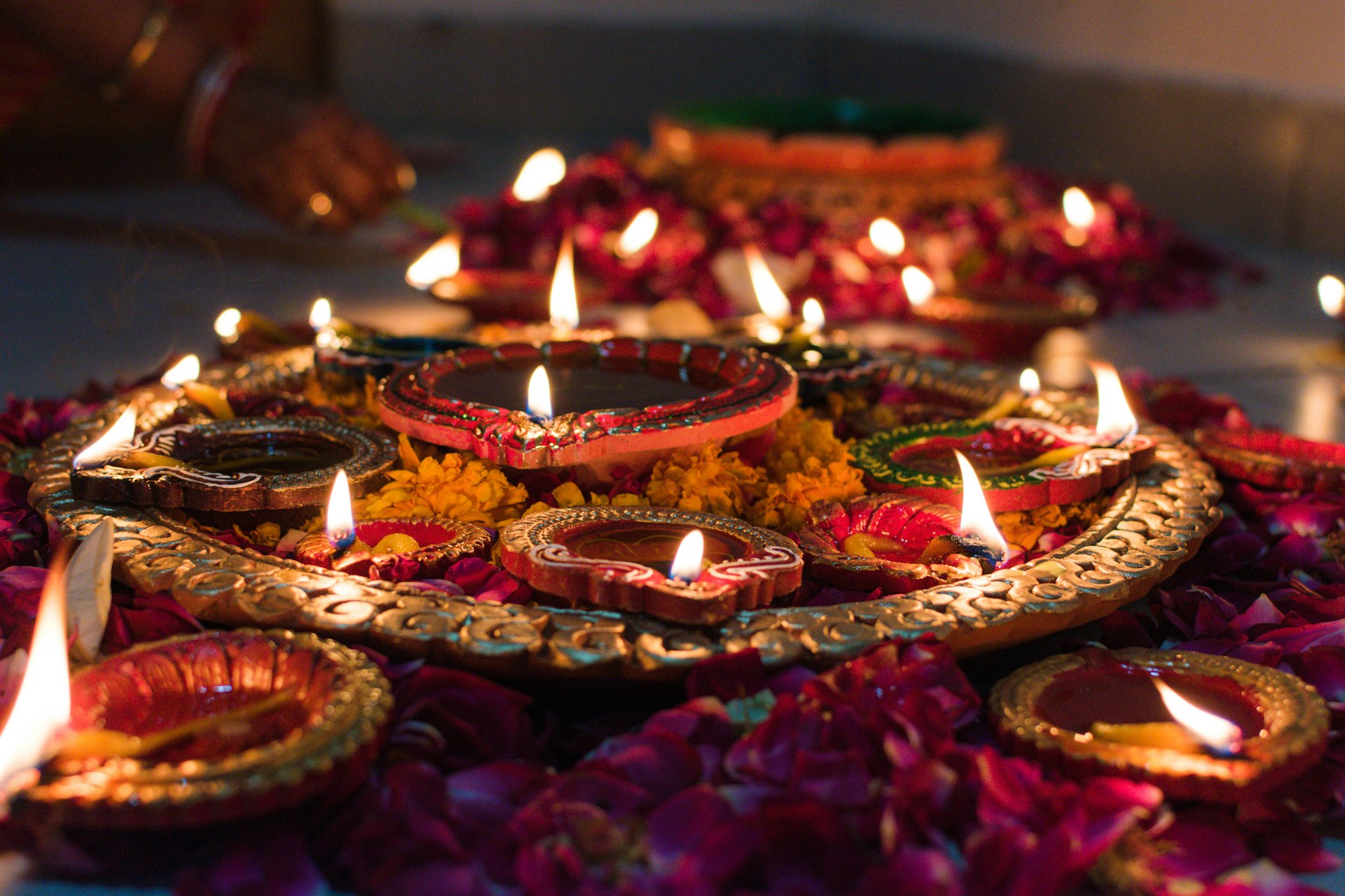 Lit clay oil lamps on a decorative tray