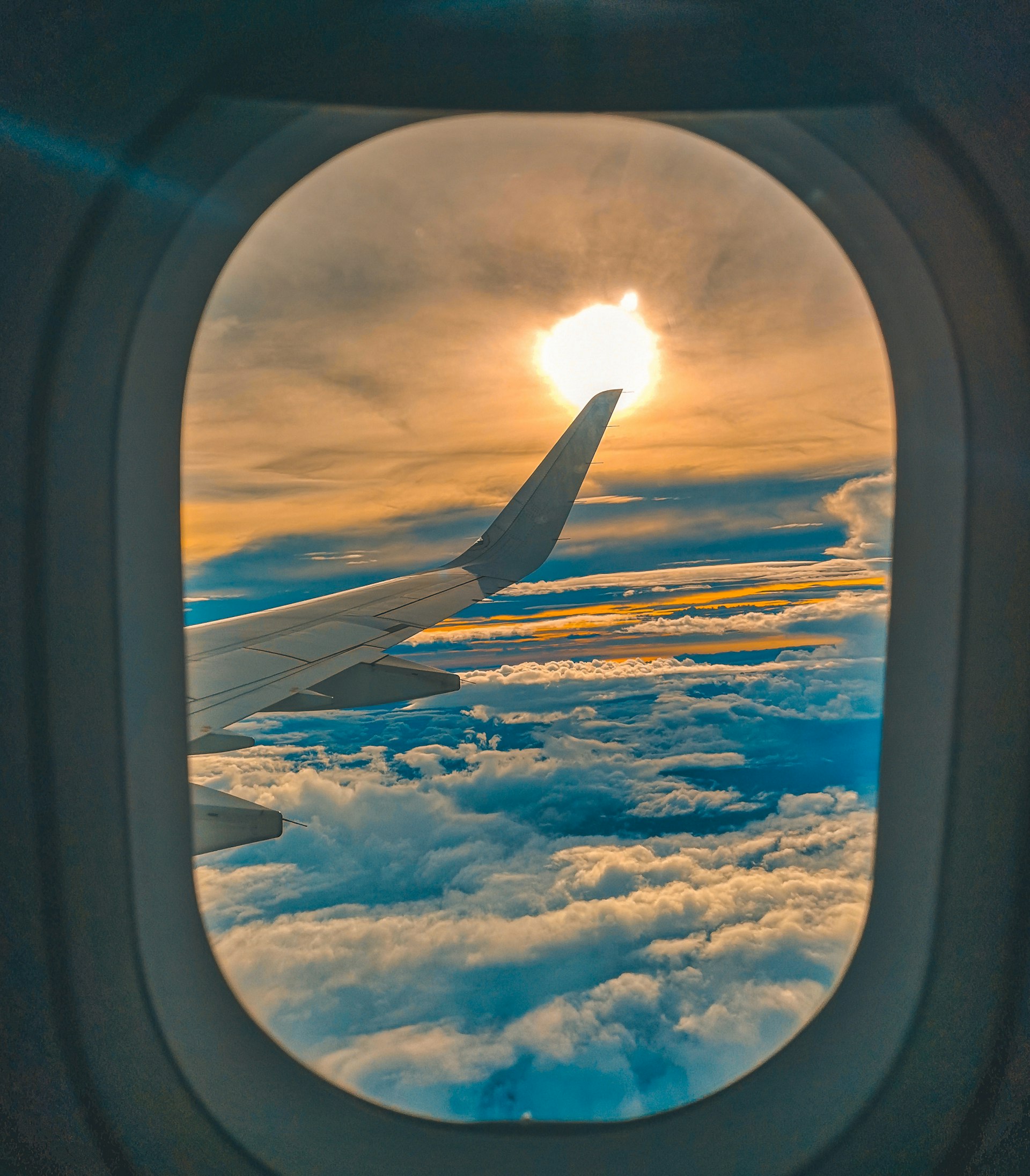 Airplane window over clouds
