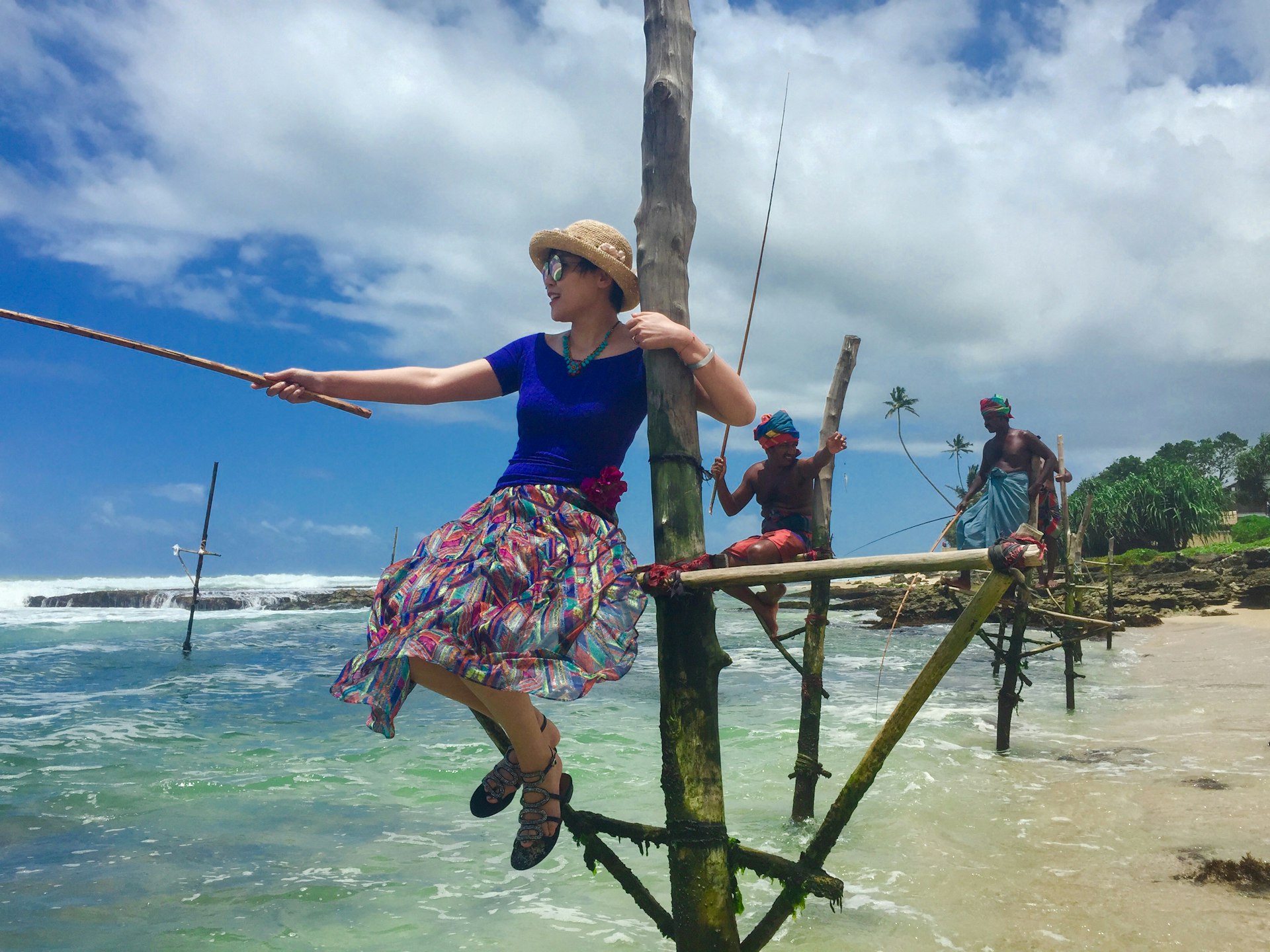 Woman in a floral dress sitting on a wooden ladder